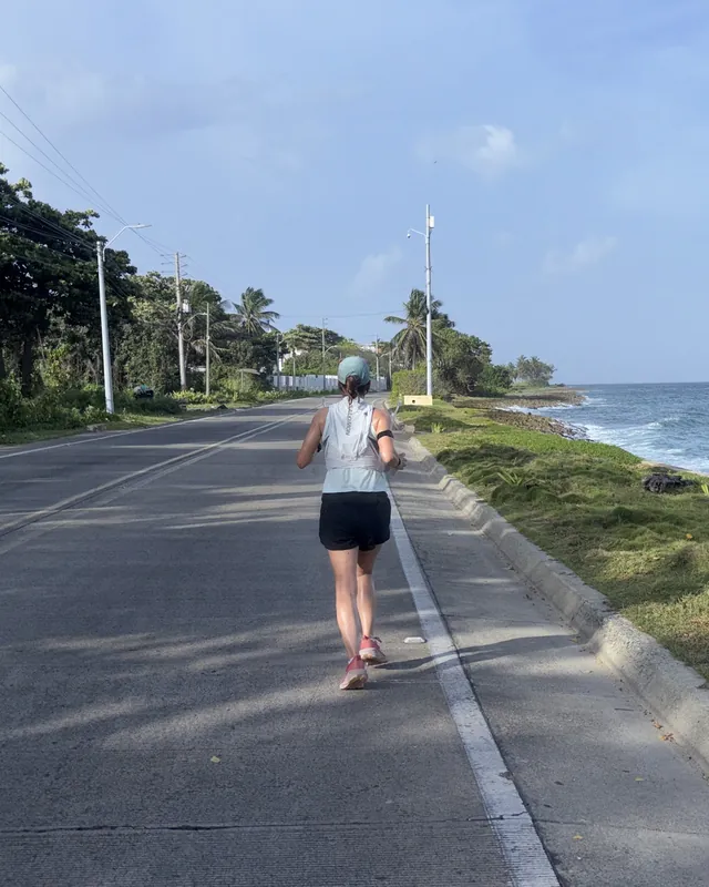 Mónica, de espaldas, corre por la carretera de la costa en San Andrés.